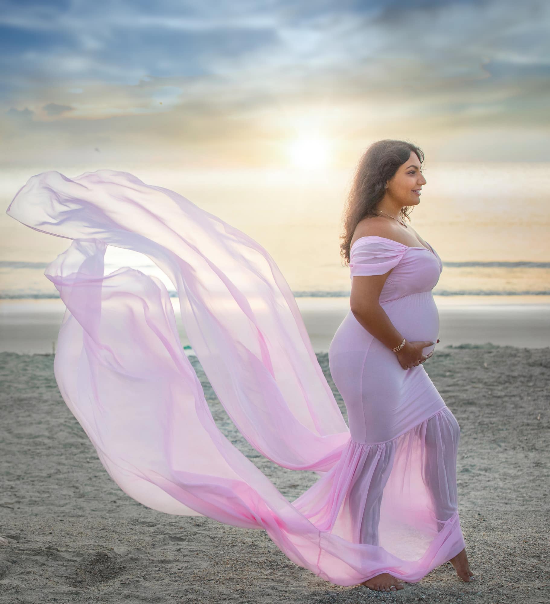 pregnant woman in purple dress on beach